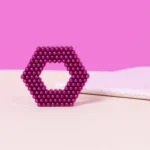 2. Glitzernde rosa Perlen in kreisförmiger Anordnung auf einem rosa Hintergrund, dekoratives Schmuckstück.