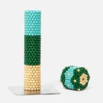 Bilder von bunten Perlenkugeln in einem Turm und einem geformten Würfel.