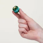 Bunte Perlenfigur auf dem Finger, detailreich und handgemacht.