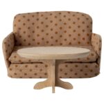 2. Detailaufnahme eines kleinen Puppenmöbel-Sofas mit Stoffbezug und Polka-Dot-Muster, kombiniert mit einem runden Holzcouchtisch.